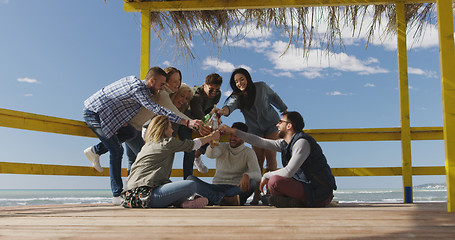 Image showing Group of friends having fun on autumn day at beach