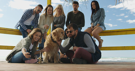 Image showing Group of friends having fun on autumn day at beach