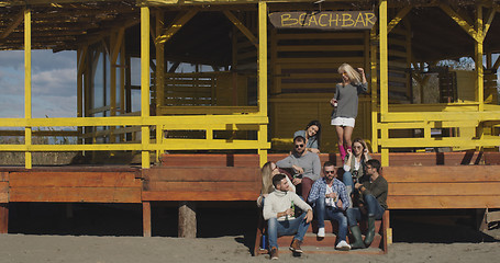 Image showing Group of friends having fun on autumn day at beach