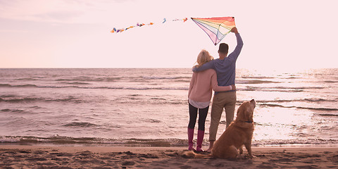 Image showing couple with dog having fun on beach on autmun day