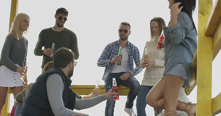 Image showing Group of friends having fun on autumn day at beach