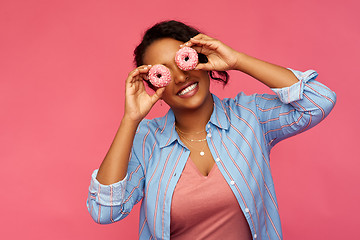 Image showing happy african american woman with eyes of donuts