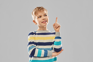 Image showing little boy in striped pullover pointing finger up