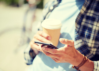 Image showing man with smartphone and coffee on city street