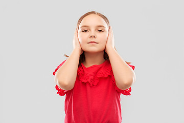 Image showing beautiful girl in red shirt closing ears by hands