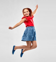 Image showing happy smiling girl in red shirt and skirt jumping