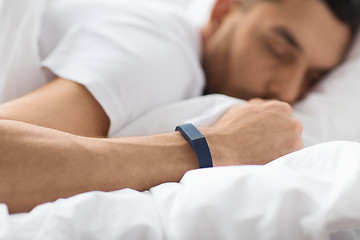 Image showing close up of man sleeping with activity tracker