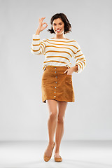 Image showing woman in pullover, skirt and shoes showing ok