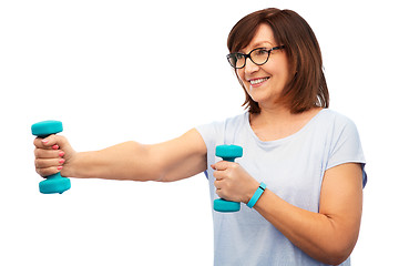 Image showing smiling senior woman with dumbbells exercising