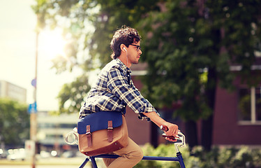 Image showing young hipster man with bag riding fixed gear bike