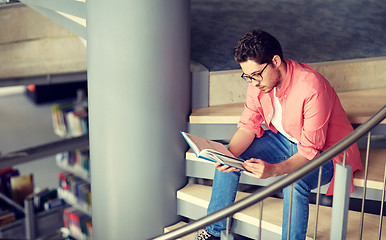 Image showing student boy or young man reading book at library