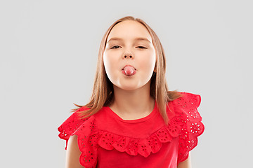 Image showing beautiful girl in red shirt showing her tongue