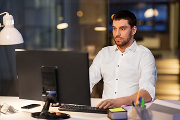 Image showing businessman with computer working at night office