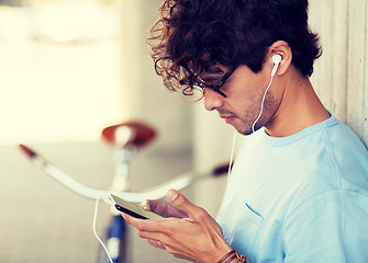 Image showing man with smartphon, earphones and bicycle