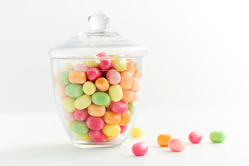 Image showing glass jar with candy drops over white background