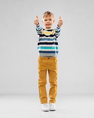 Image showing smiling boy in striped pullover showing thumbs up