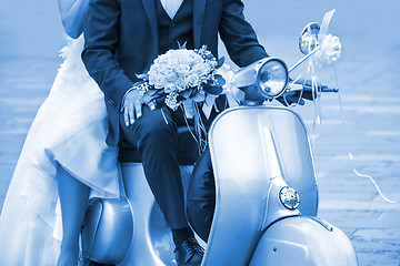 Image showing Young newlywed just married, posing on an old  scooter. Clas