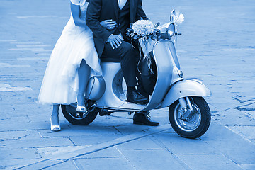 Image showing Young newlywed just married, posing on an old scooter. Clas