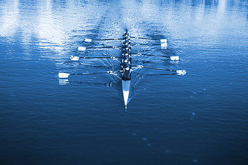 Image showing Boat coxed eight Rowers rowing on the tranquil lake. Classic Blu