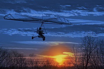 Image showing The motorized hang glider fly in the sunset. Classic Blue Panton