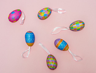 Image showing Paper colorful Easter eggs lie on a gently pink background. Easter concept.