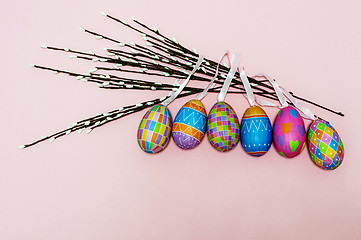 Image showing Paper colorful Easter eggs lie on a gently pink background. Easter concept.