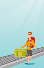 Image showing Man picking up suitcase from conveyor belt.