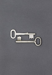 Image showing Two keys on gray paper background, close up