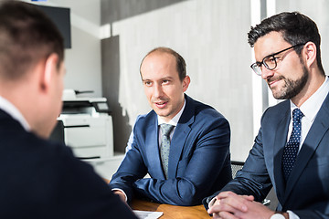 Image showing Team of confident successful business people discussing the contract terms at business meeting in modern corporate office.