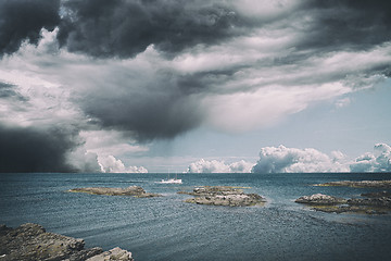 Image showing Small boat in dramatic cloudy weather