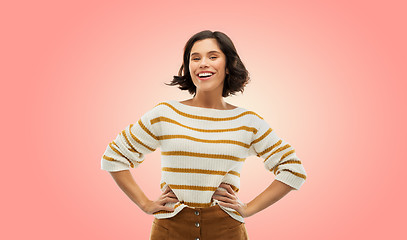 Image showing smiling woman in pullover with hands on hips