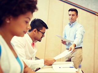 Image showing teacher giving tests to students at lecture