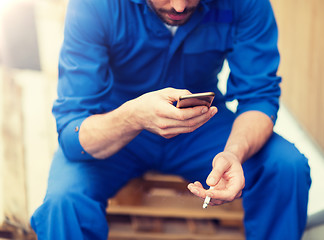 Image showing auto mechanic smoking cigarette at car workshop