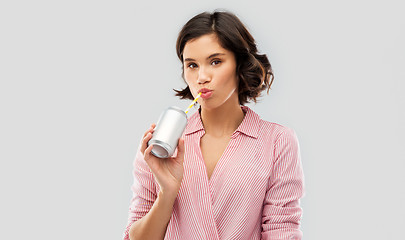 Image showing woman drinking soda from can with paper straw