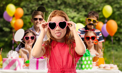 Image showing naughty red haired girl in heart shaped sunglasses