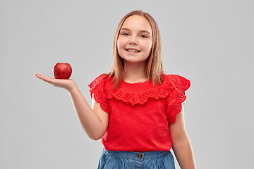 Image showing beautiful smiling girl holding red apple on palm