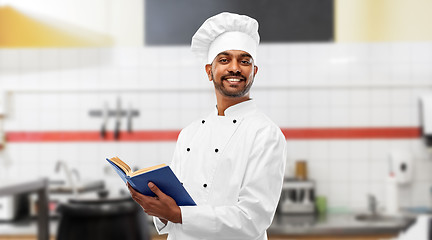 Image showing happy indian chef with cookbook at kitchen