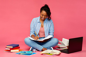 Image showing african american student woman writing to notebook