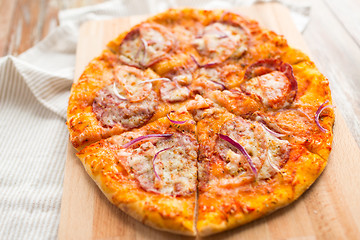 Image showing close up of homemade pizza on wooden table