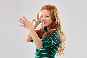 Image showing red haired girl having fun and making big nose