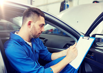 Image showing auto mechanic man with clipboard at car workshop