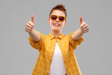 Image showing happy teenage girl in sunglasses showing thumbs up