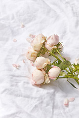 Image showing Bouquet of flowers on bed sheets.