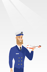 Image showing Cheerful airline pilot with the model of airplane.