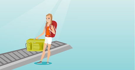 Image showing Woman picking up suitcase from conveyor belt.