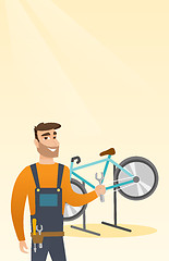 Image showing Caucasian bicycle mechanic working in repair shop.