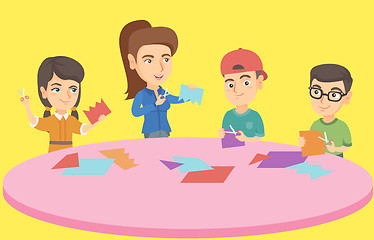 Image showing Teacher and children cutting paper with scissors.