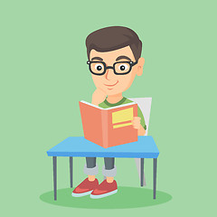 Image showing Student sitting at the table and reading a book.