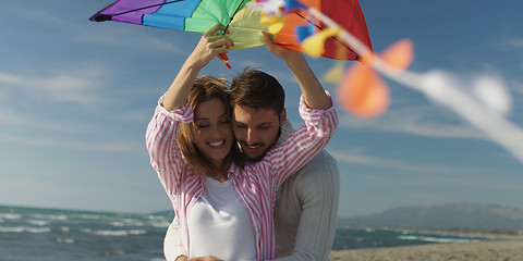 Image showing Happy couple having fun with kite on beach