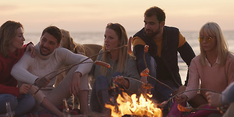 Image showing Group Of Young Friends Sitting By The Fire at beach